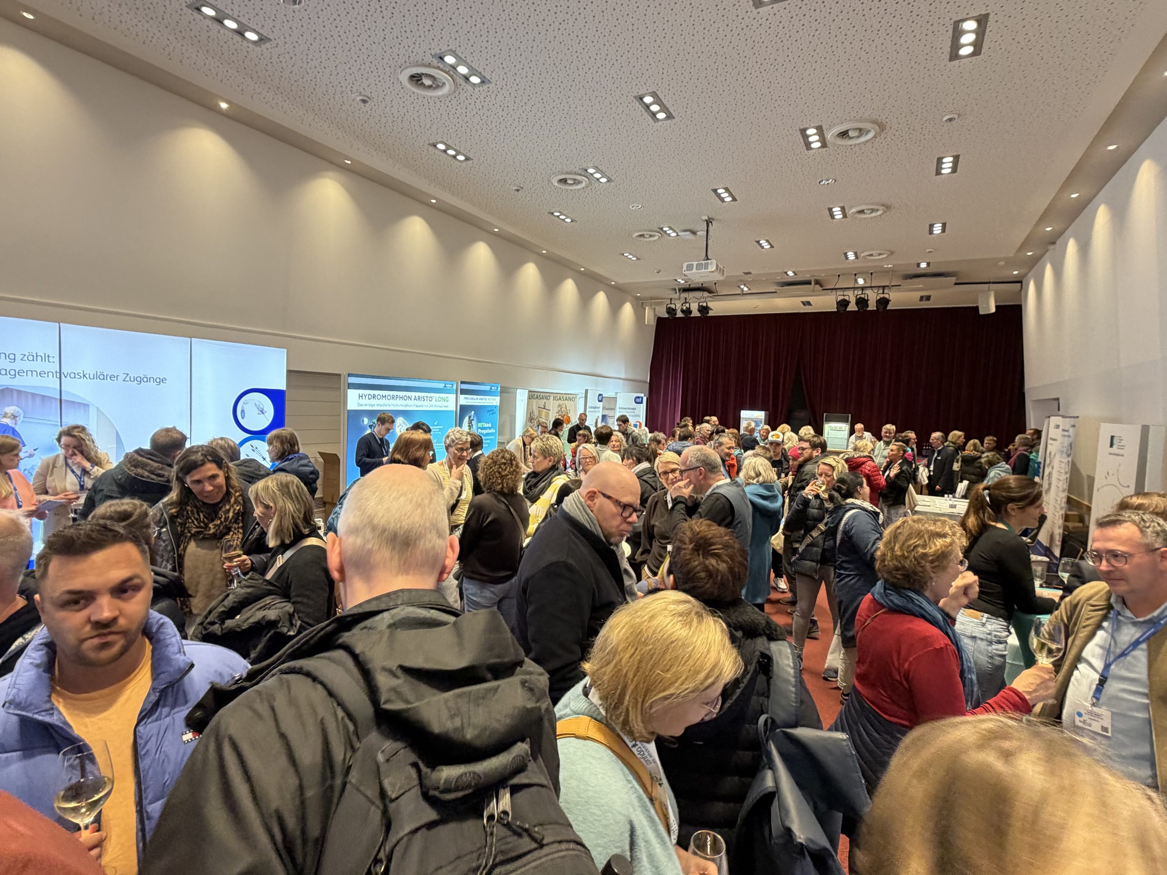 Teilnehmende im Austausch in der Industrieausstellung der Internationalen Sylter Palliativtage